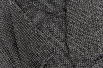Photo that shows a folded gray textured waffle weave blanket.