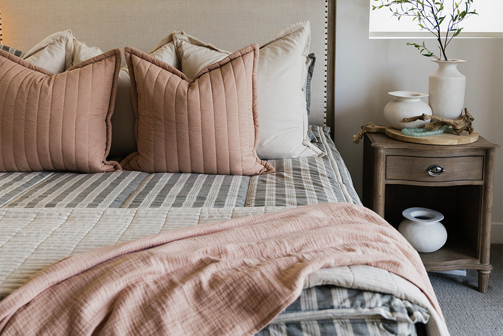 Classic neutral stripe zipper bedding with cream and terracotta accessories.