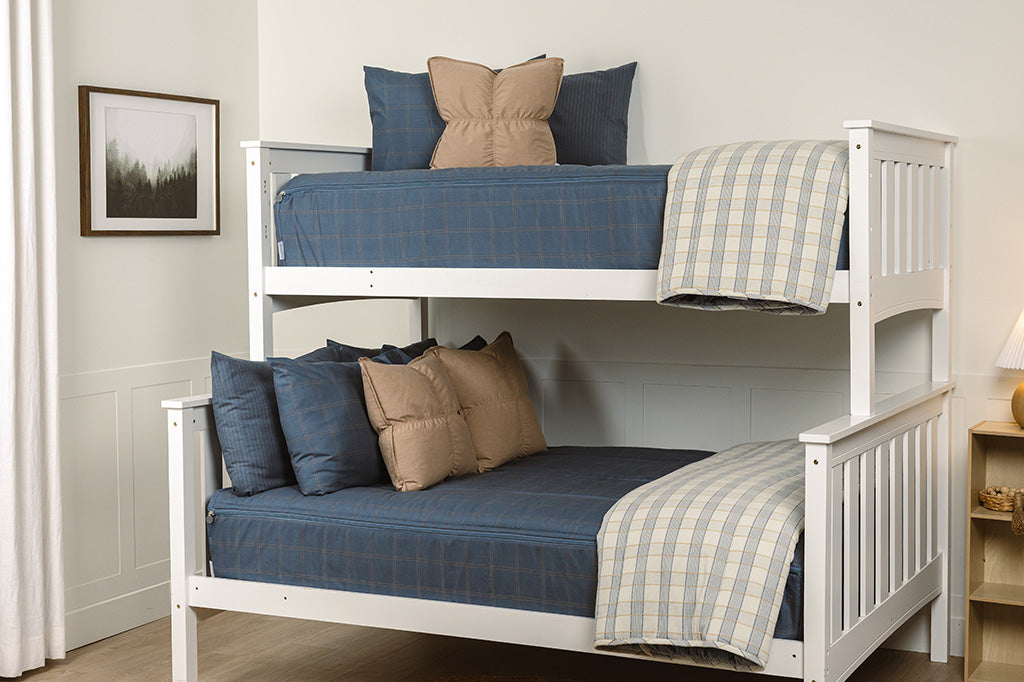 A bunk bed with the top twin and bottom full made with slate blue grid printed zipper bedding styles with light brown and blue plaid accessories. 