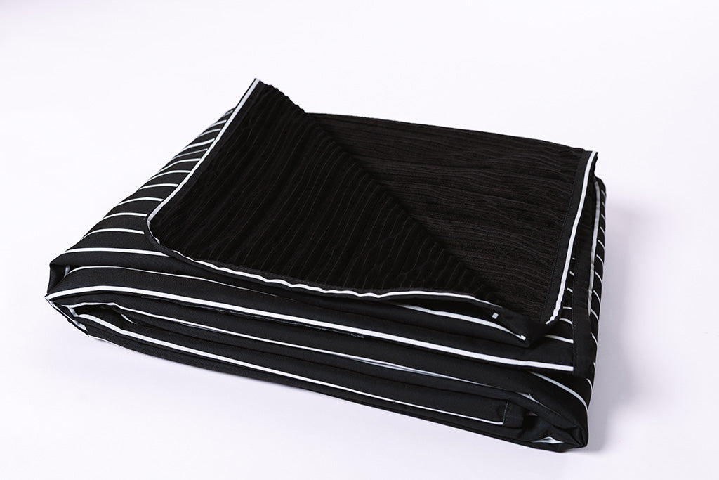 The stadium blanket folded on a white background. 