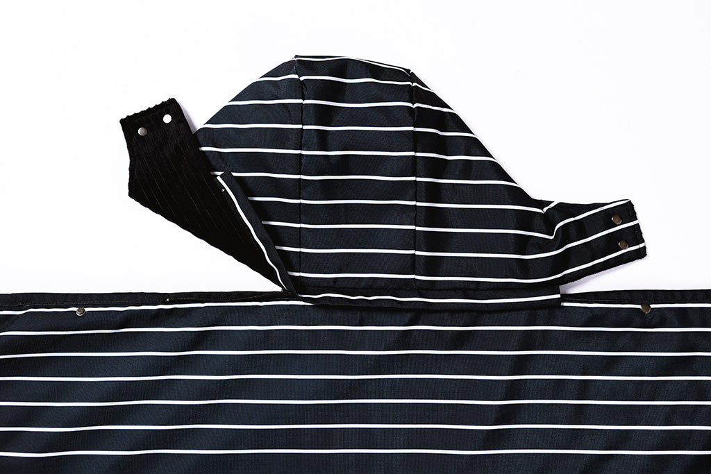Partially unzipped detachable hood of the stadium blanket on a white background.
