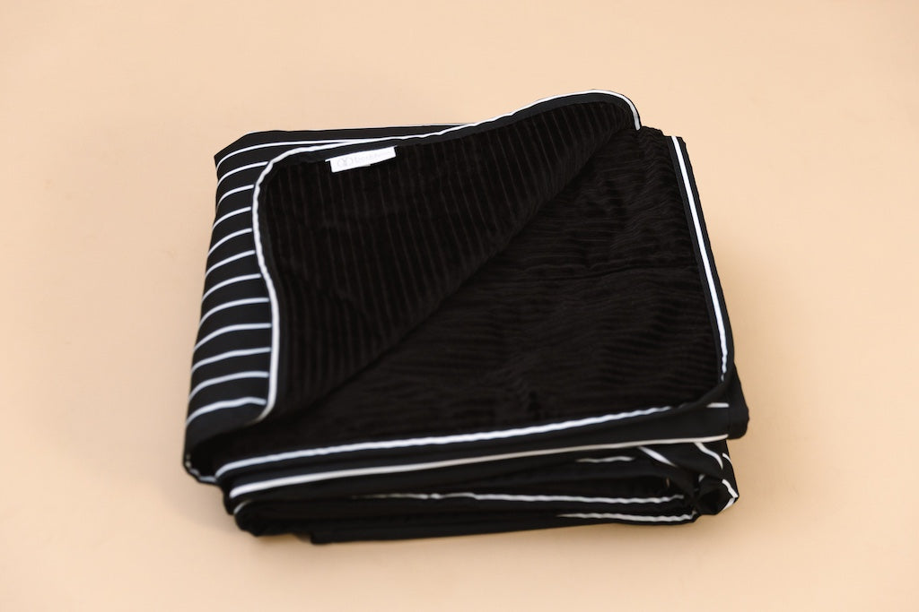 The stadium blanket folded on a tan background. 