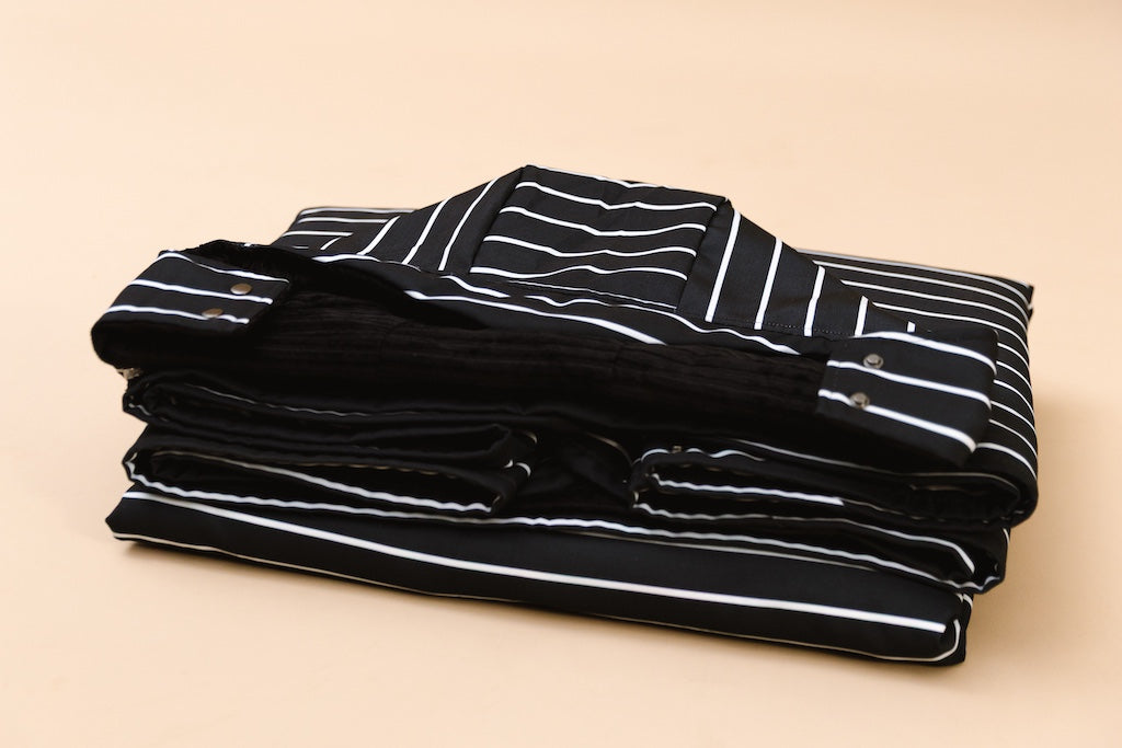 Beddy's water and wind resistant stadium blanket folded on a tan background.