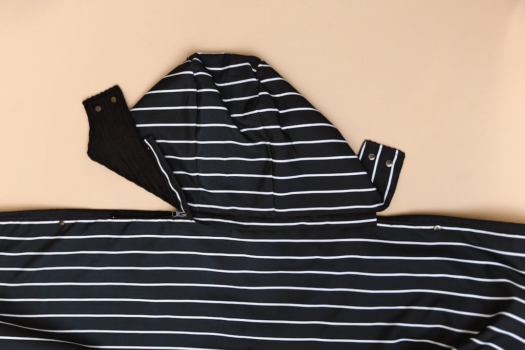 Partially unzipped detachable hood of the stadium blanket on a tan background.
