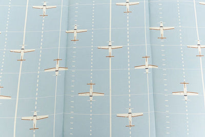up close of light blue bedding with airplane design
