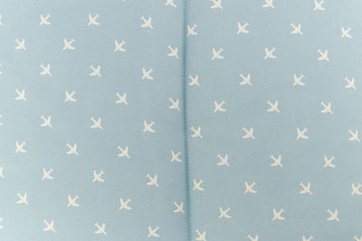 up close of light blue sheet with little white airplane design
