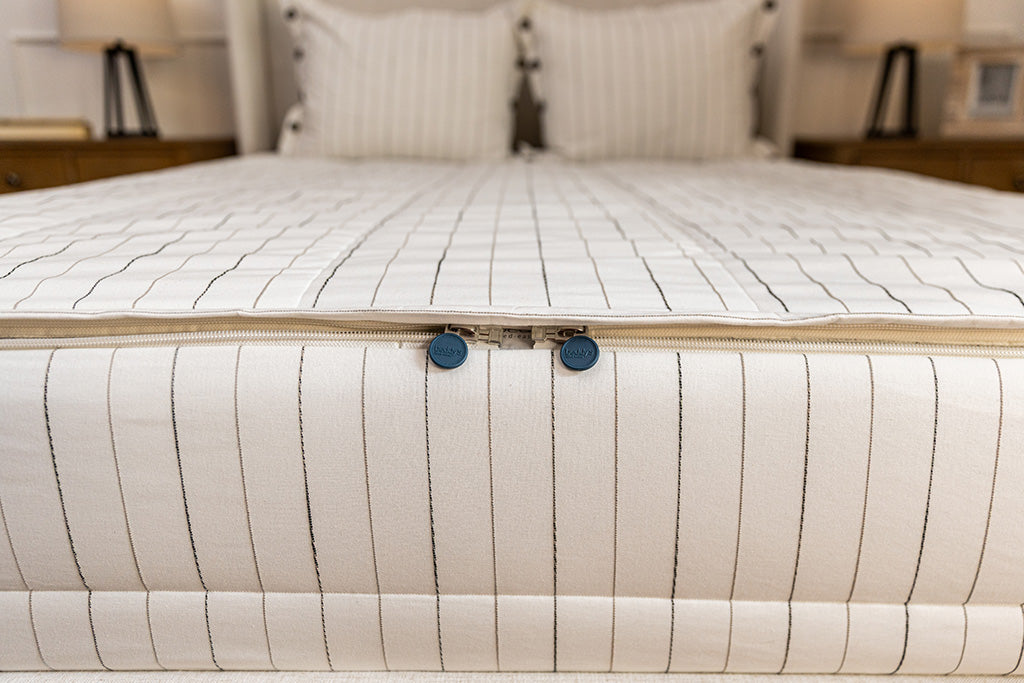 End of bed showing double zippers on neutral stripe zipper bedding.