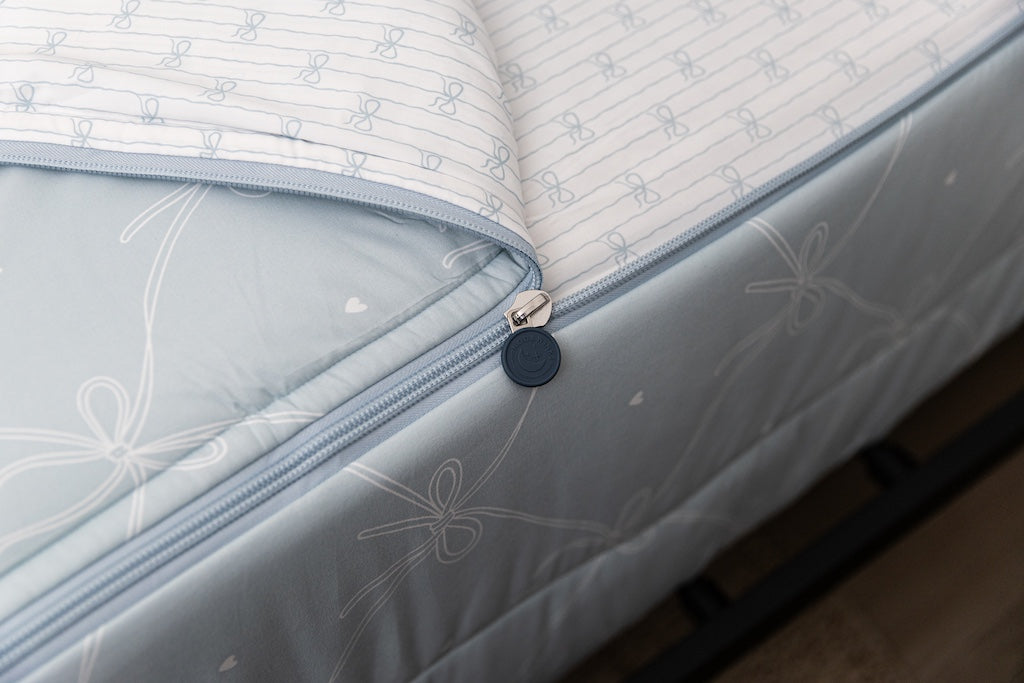 A tight shot of the zipper feature on a set of bows printed zipper bedding.