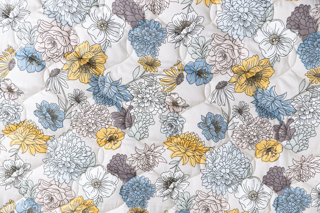 A close up of the blue and yellow floral print on this blanket