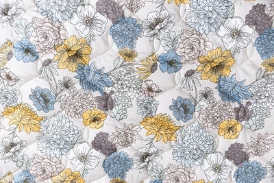 A close up of the blue and yellow floral print on this blanket