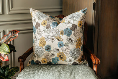 A multicolor floral euro patterned pillow arranged on an antique chair.