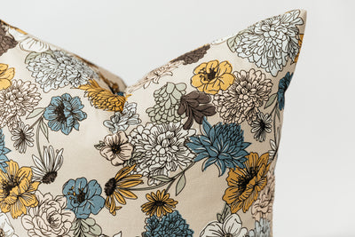 A close up view of a multicolor floral euro patterned pillow arranged on a white background.