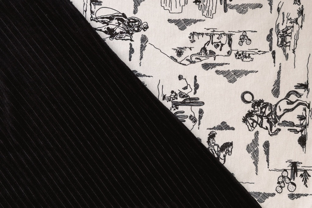A close-up front and back view of a cream and black western printed travel blanket. 