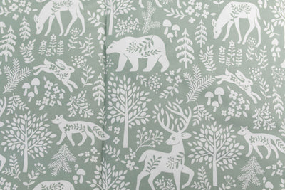 A close up on the print of a sage green forest animal kids zipper bedding set