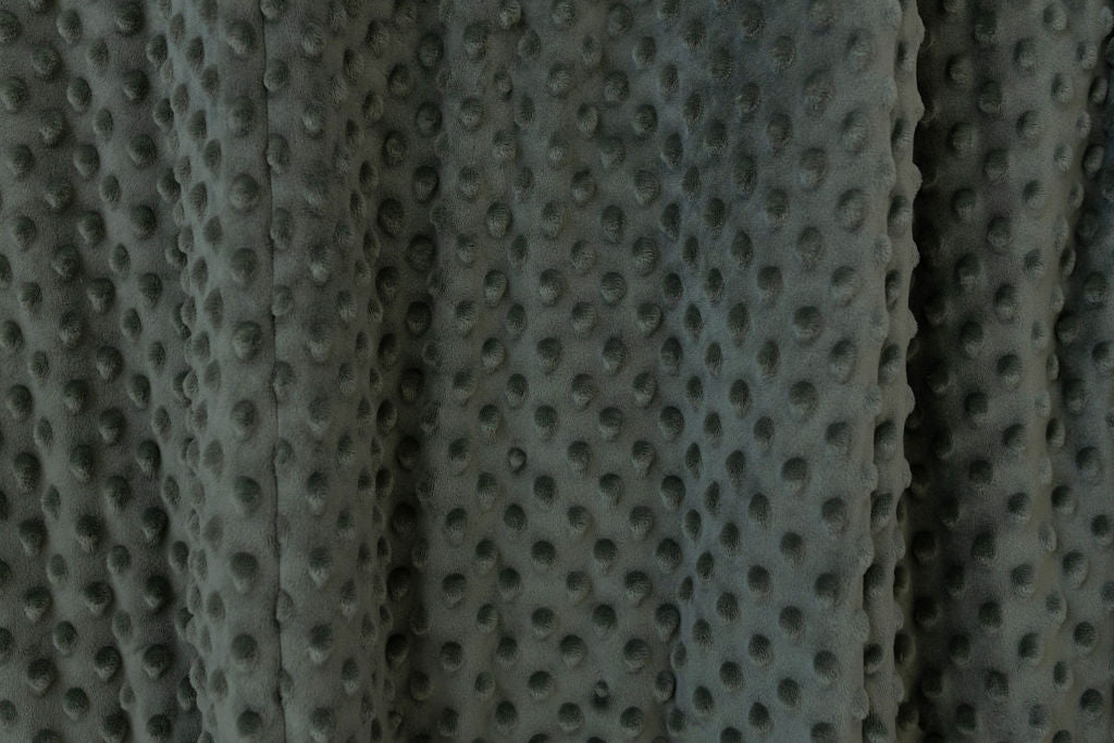 A close up view of a dark green minky blanket.