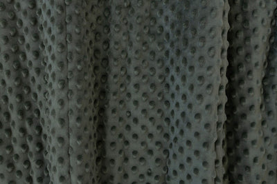 A close up view of a dark green minky blanket.