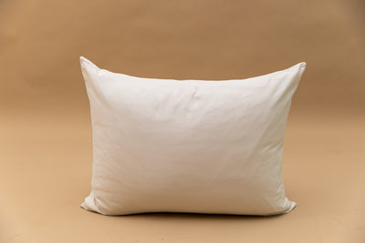 An ivory pillowcase displayed on a tan backdrop.