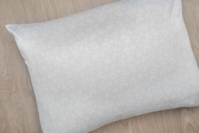 White satin pillowcase on hardwood floor