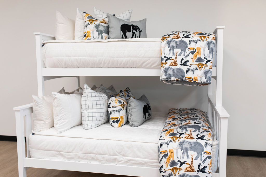 Bunk beds with white zipper bedding styled with animal print, white and gray pillows