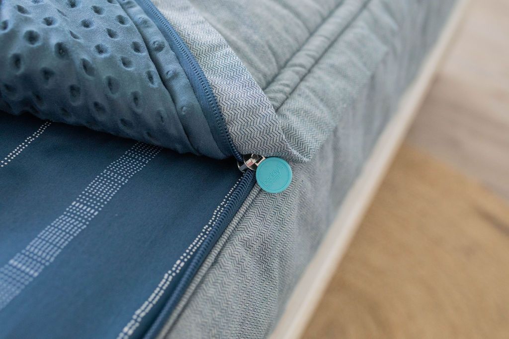 Close up view of unzipped Light blue zipper bedding revealing minky inner lining. Beddy's branded zipper pull tab