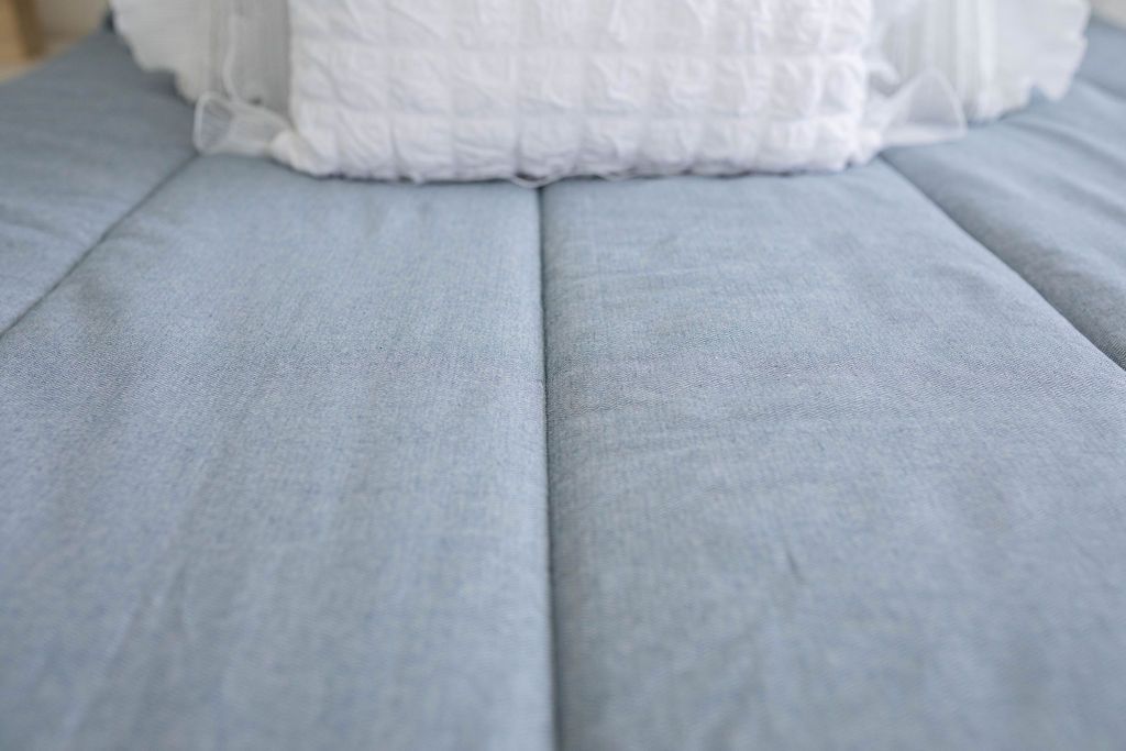 Close up view of Light blue zipper bedding with white pillows