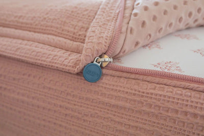 Unzipped pink zipper bedding with Beddy's marked zipper pull tab