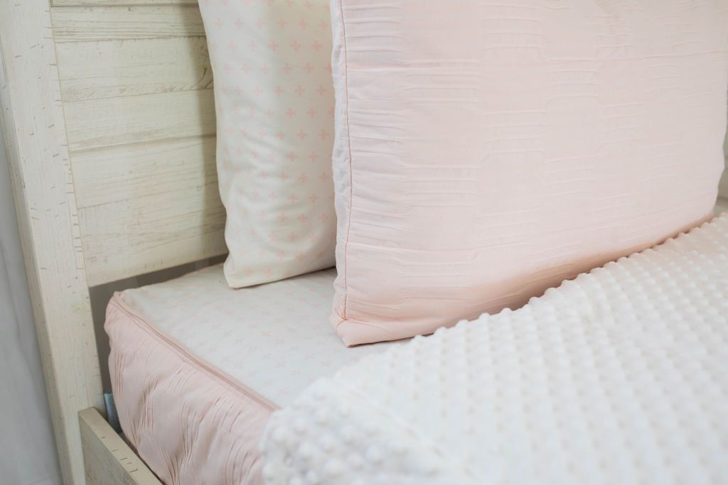 White pillowcase with light pink pattern, pink sham, and pink unzipped zipper bedding with white minky inner lining 