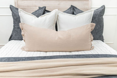 White zipper bedding styled with grey, white and cream pillows and cream and grey blankets