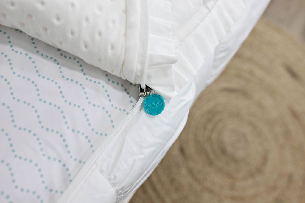 photo showing zipper edge of white textured bedding with white and blue dotted lines