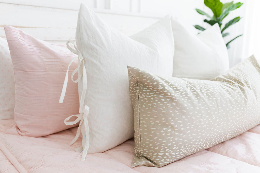 Pink zipper bedding with pink, white and cream pillows