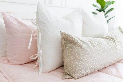 Pink zipper bedding with pink, white and cream pillows