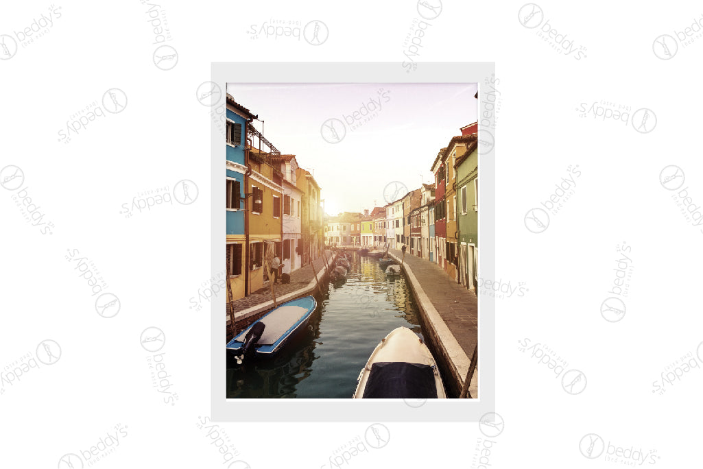 A city on water with boats and colorful buildings digital artwork showcased in a frame. 
