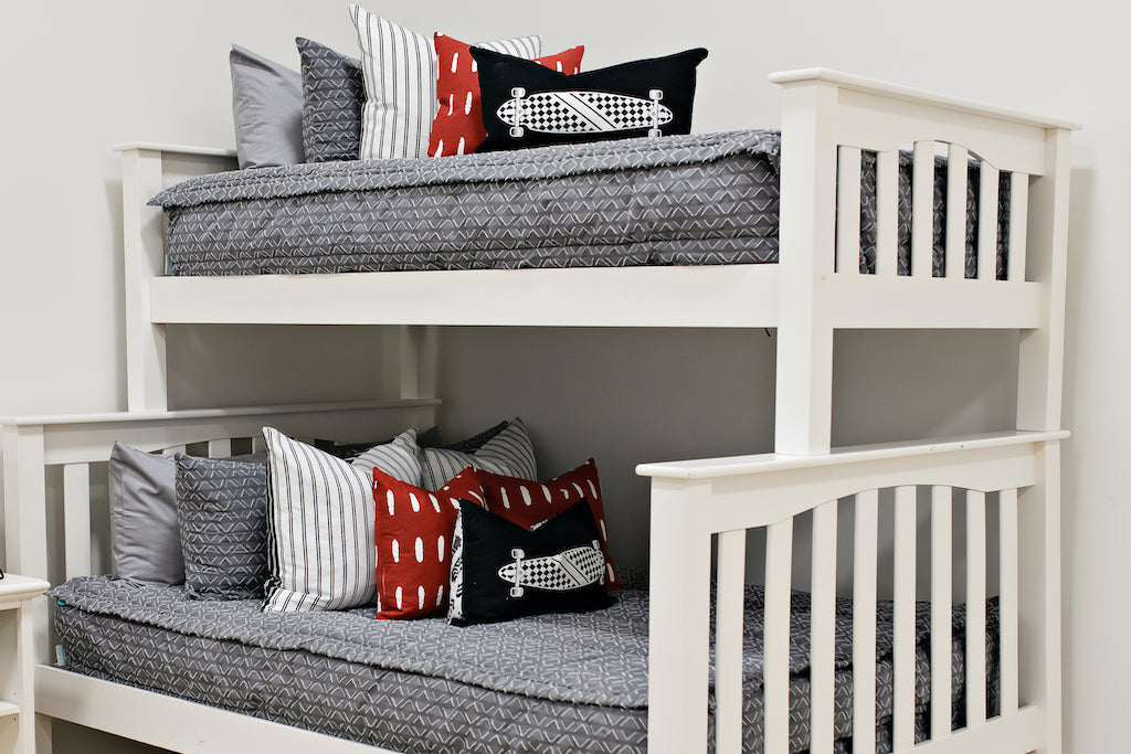 bunk bed with Gray bedding with textured diamond with white and black striped euro, red pillow with white dashes, black lumbar with white lumbar print 