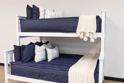 Dark blue zipper bedding with blue matching pillows. Styled with white pillows and throw blankets