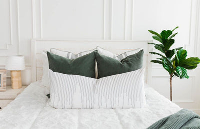 White bedding with texturized diamond design with moss green corduroy euro, white euro with moss green lines, white XL lumbar with moss green stitching and moss green knitted chenille throw with tassels