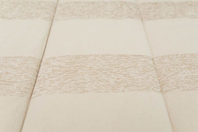 Close up of texture and striped pattern on tan zipper bedding