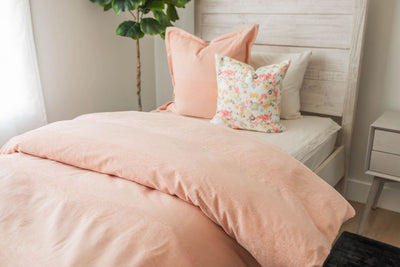 Pink duvet bedding on bed with matching accessories