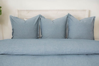 Light blue duvet on white zipper bedding styled with blue pillows