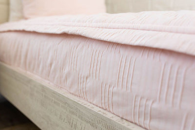 Side view of pink zipper bedding. Close up detailing texture of bedding