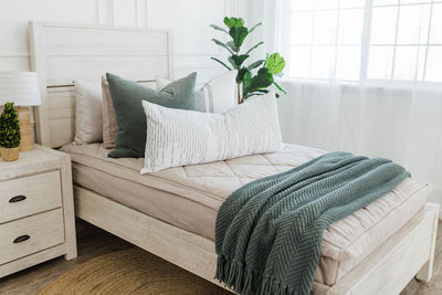 twin bed with Tan textured zipper bedding moss green corduroy euro, white euro with moss green lines, white XL lumbar with moss green stitching and moss green knitted chenille throw with tassels