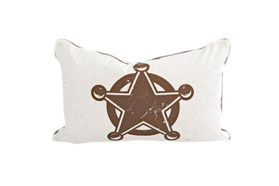 White lumbar pillow with brown sheriff badge design