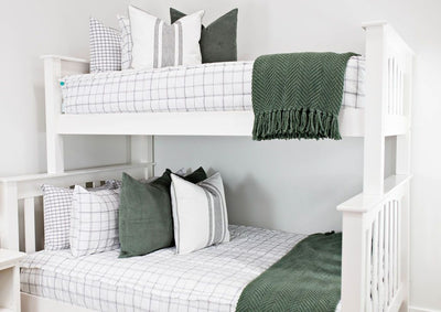 White bunk bed with white and black grid pattered bedding, moss green corduroy euros and white and green striped euro with moss green chenille textured blanket