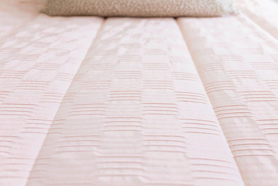 Detailed close up image showing texture of pink zipper bedding