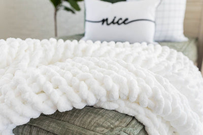 White and fluffy chain woven blanket on green zipper bedding