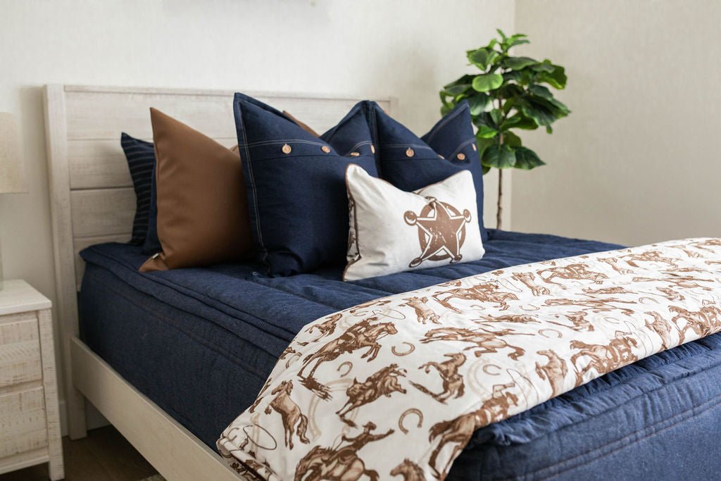 Dark blue zipper bedding with matching and brown leather pillows. Matching sheriff cowboy pillow and blanket