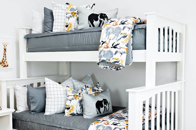 bunk bed with Gray zipper bedding with white and black grid patterned euro, safari animal print pillow, gray lumbar with embroidered elephant and safari animal print blanket