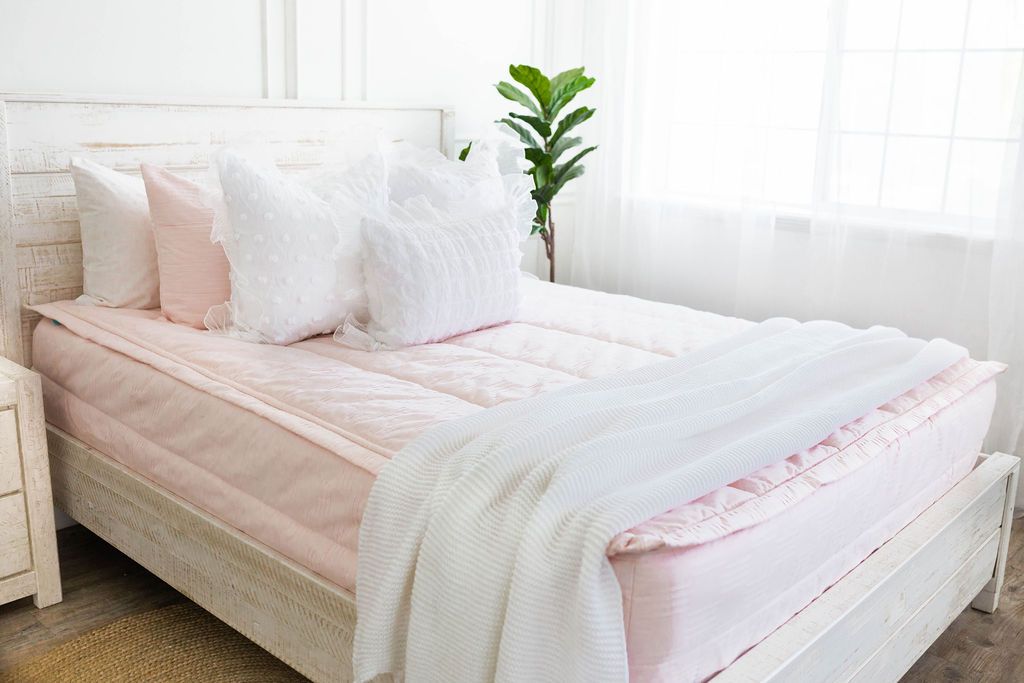 Pink zipper bedding with white pillowcases and shams. Pink shams and white throw blanket