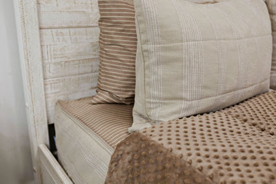 Neutral tan bedding with brown striped pillowcase and brown minky interior