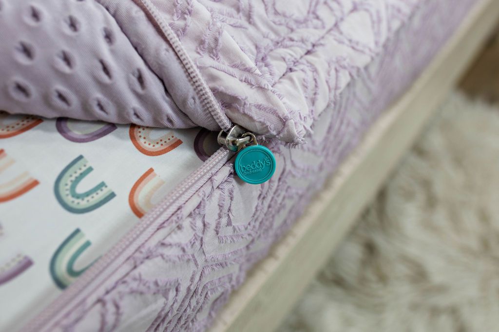 photo showing zipper edge on purple bedding with rainbow sheets