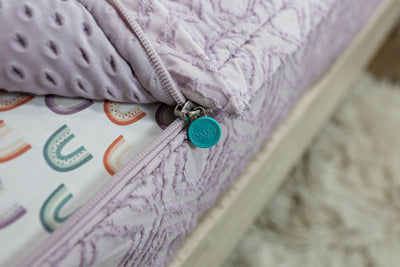 photo showing zipper edge on purple bedding with rainbow sheets